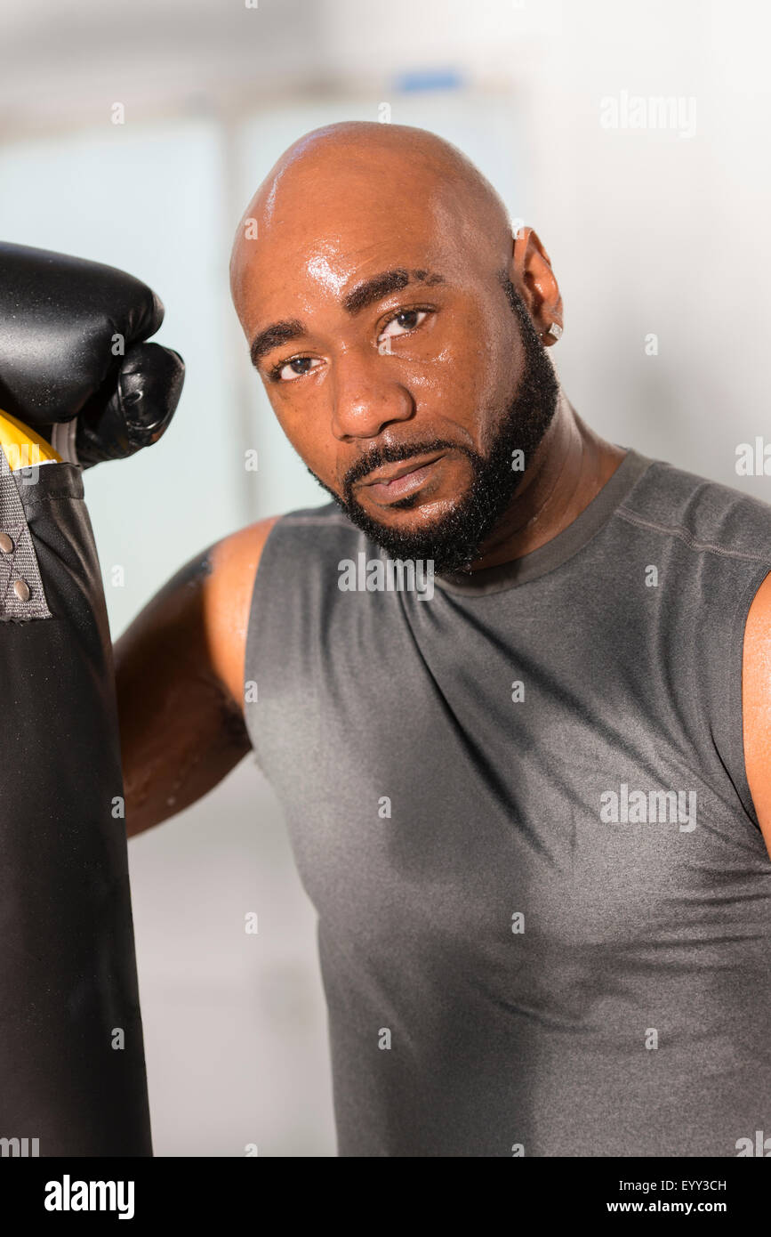 Black boxer training with punching bag Stock Photo