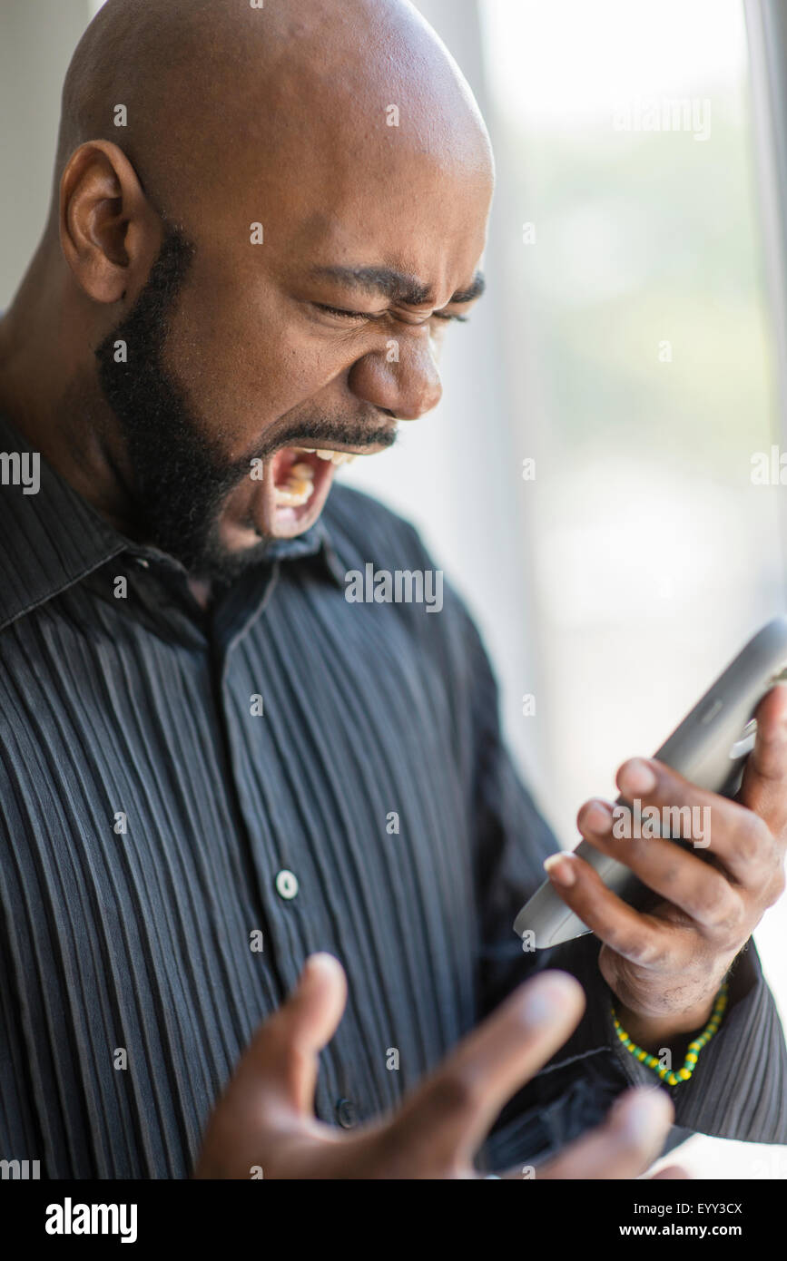 Man menacingly screaming at the phone Stock Photo