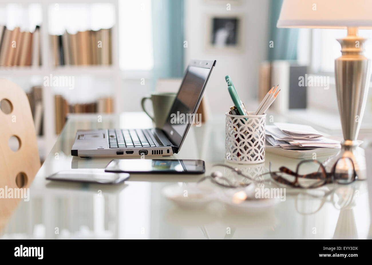 Laptop, cell phone and office supplies on desk Stock Photo