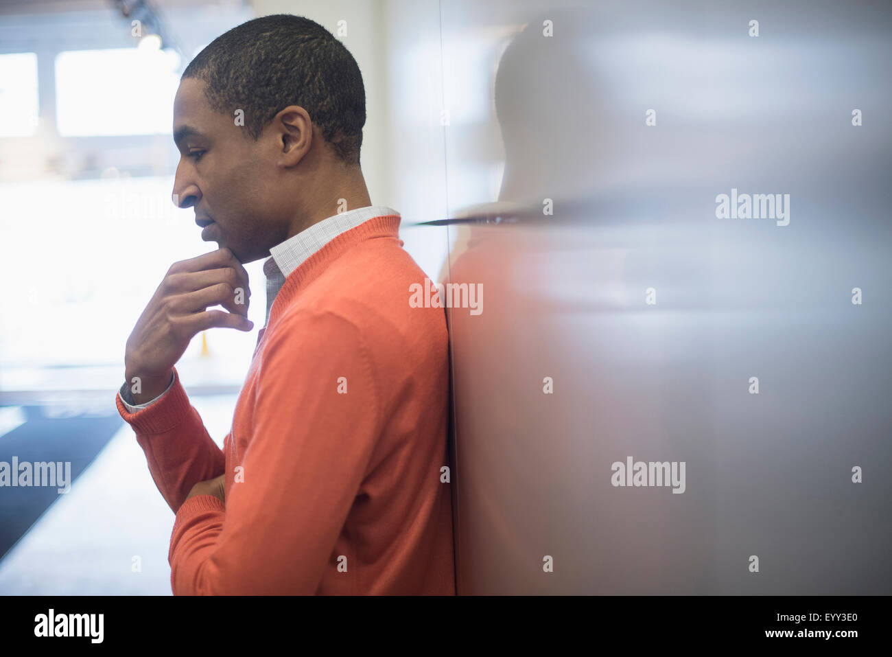 Black businessman leaning on wall Stock Photo
