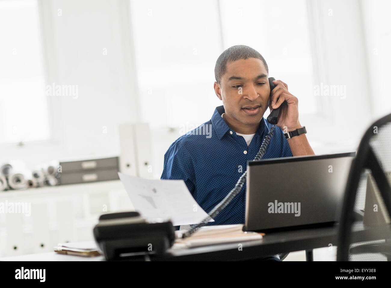 Black businessman talking on telephone in office Stock Photo