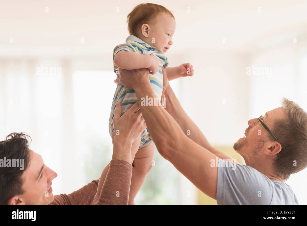 Caucasian gay fathers holding baby Stock Photo