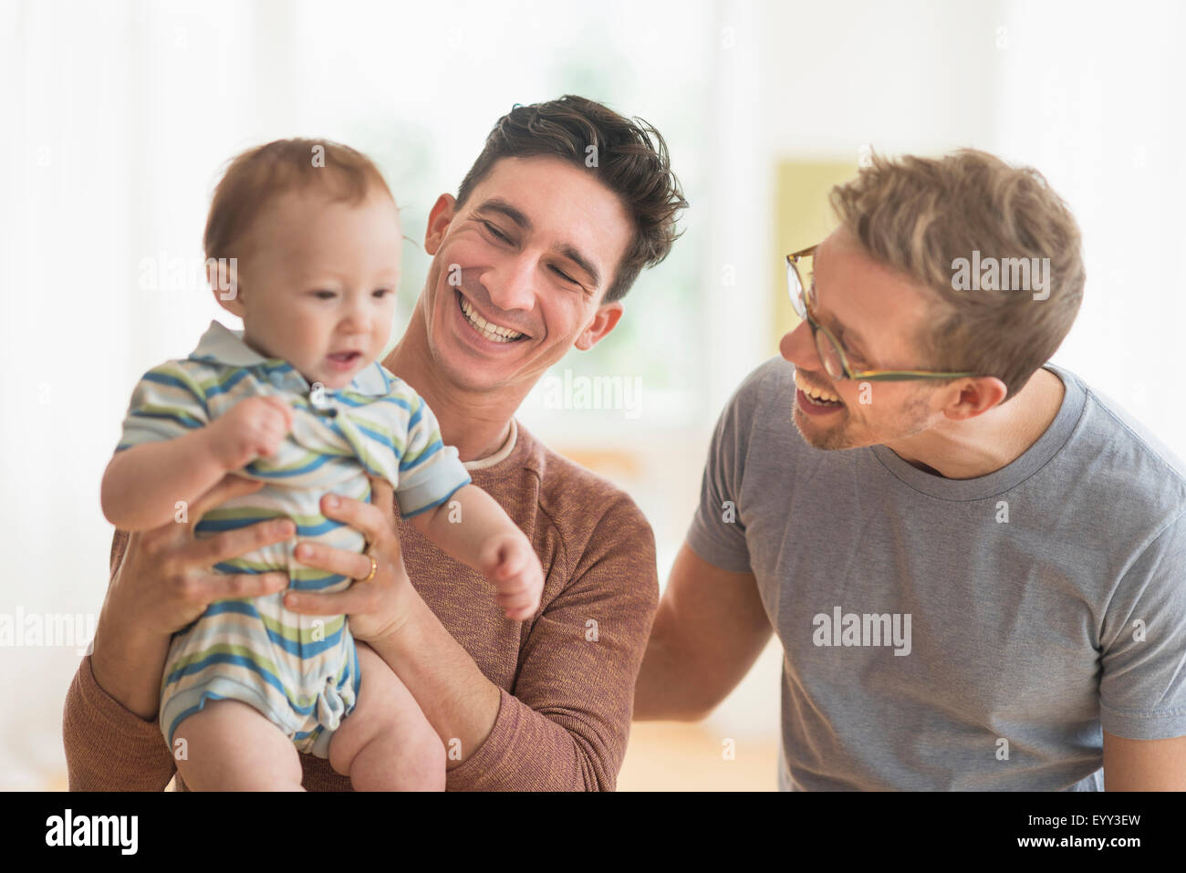 Caucasian gay fathers holding baby Stock Photo