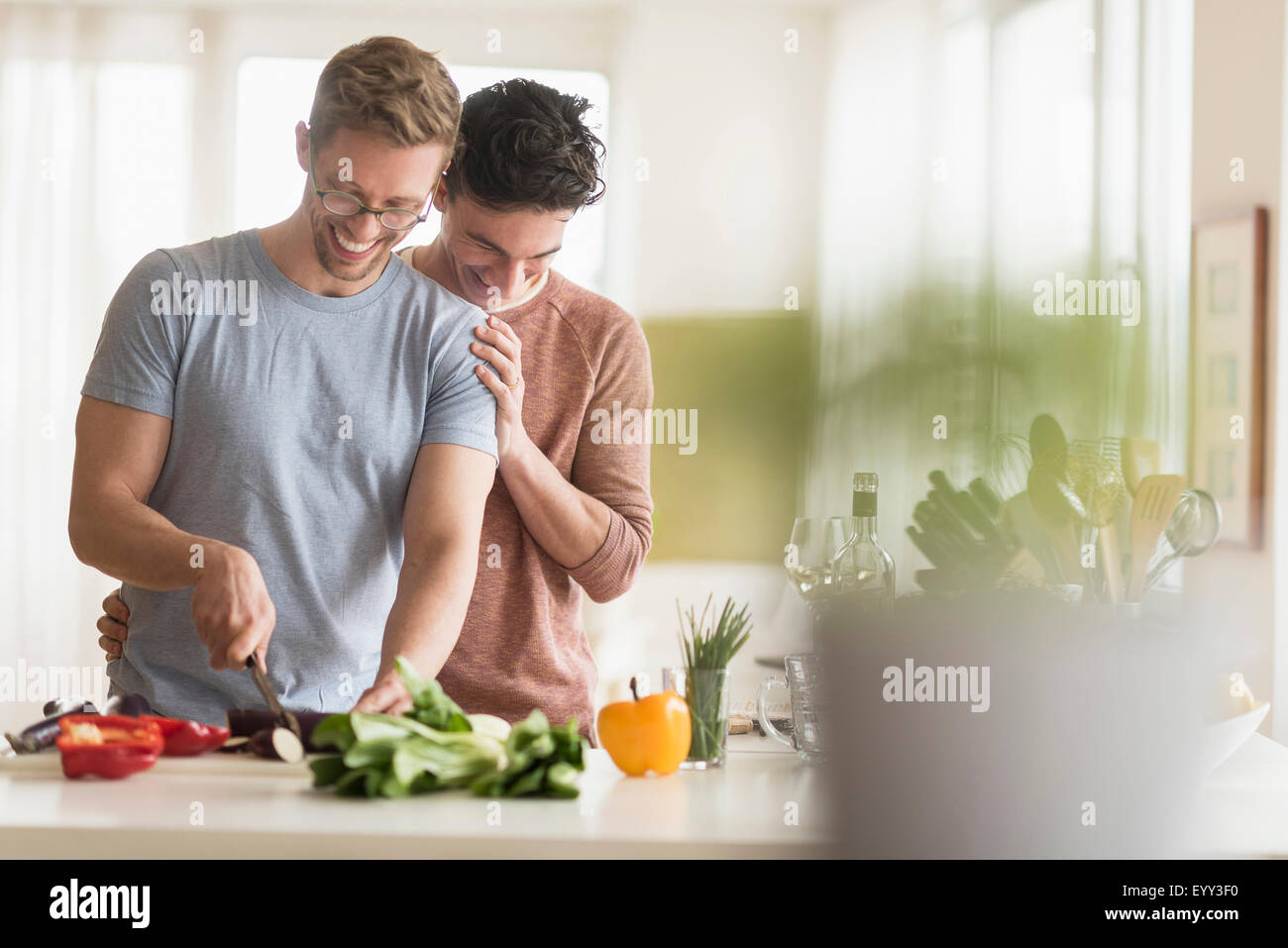Caucasian gay couple cooking in kitchen Stock Photo