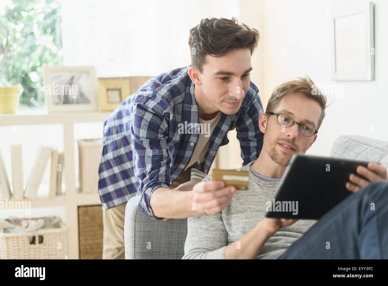 Caucasian gay couple shopping online on digital tablet Stock Photo