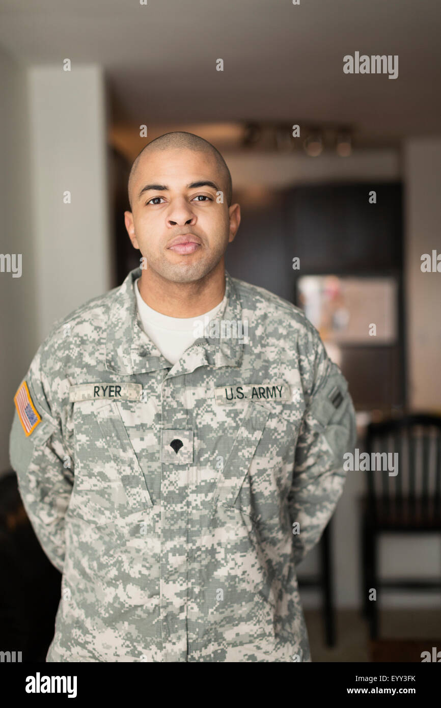 Mixed race soldier standing in living room Stock Photo