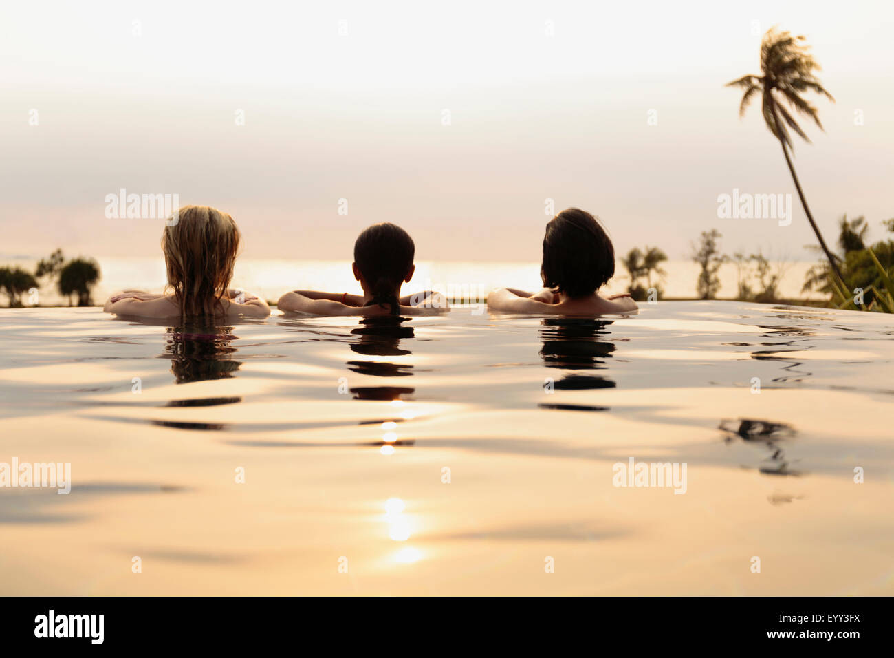 Women admiring scenic view in infinity pool Stock Photo