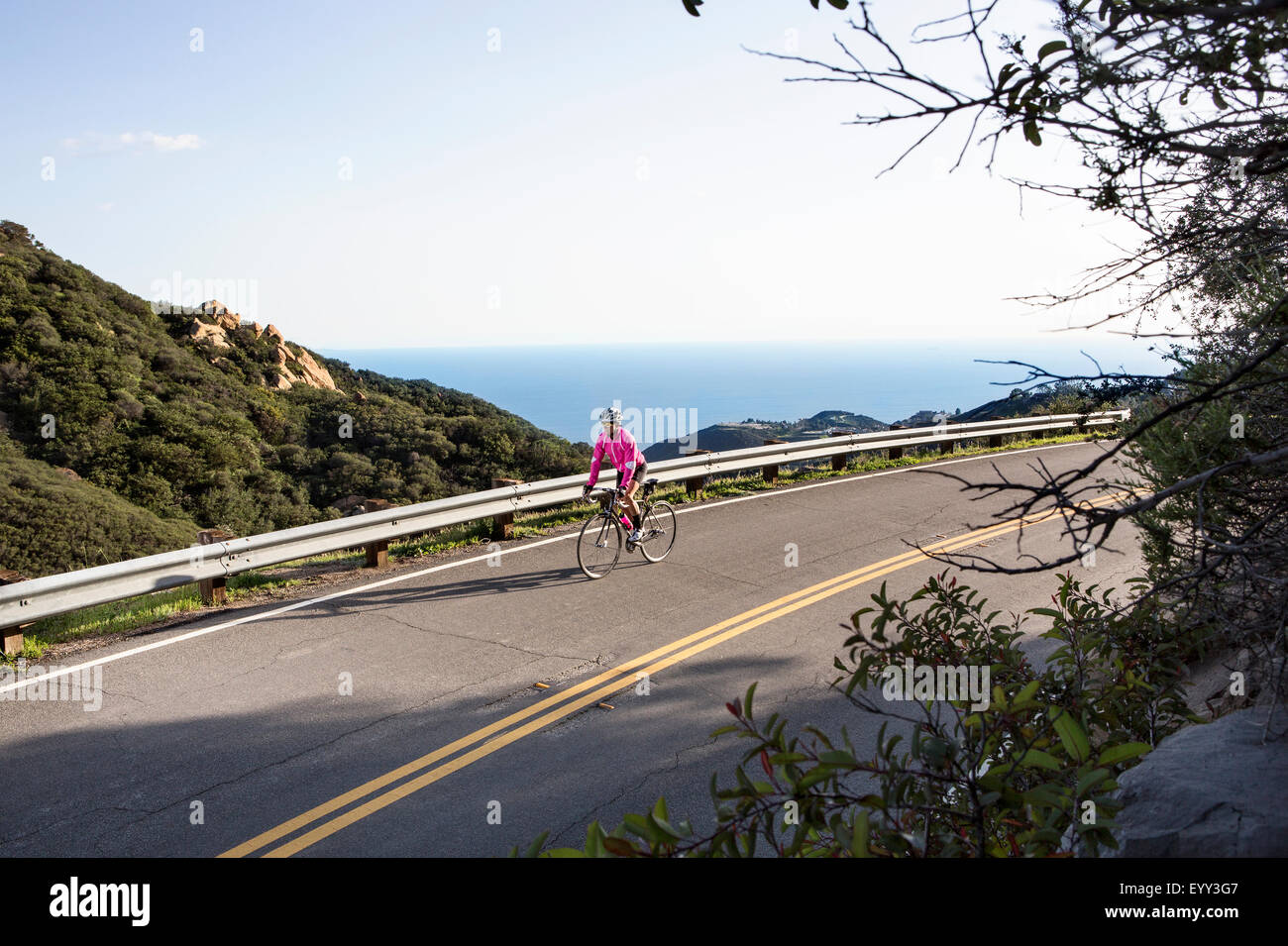 Caucasian woman biking on remote mountain road Stock Photo