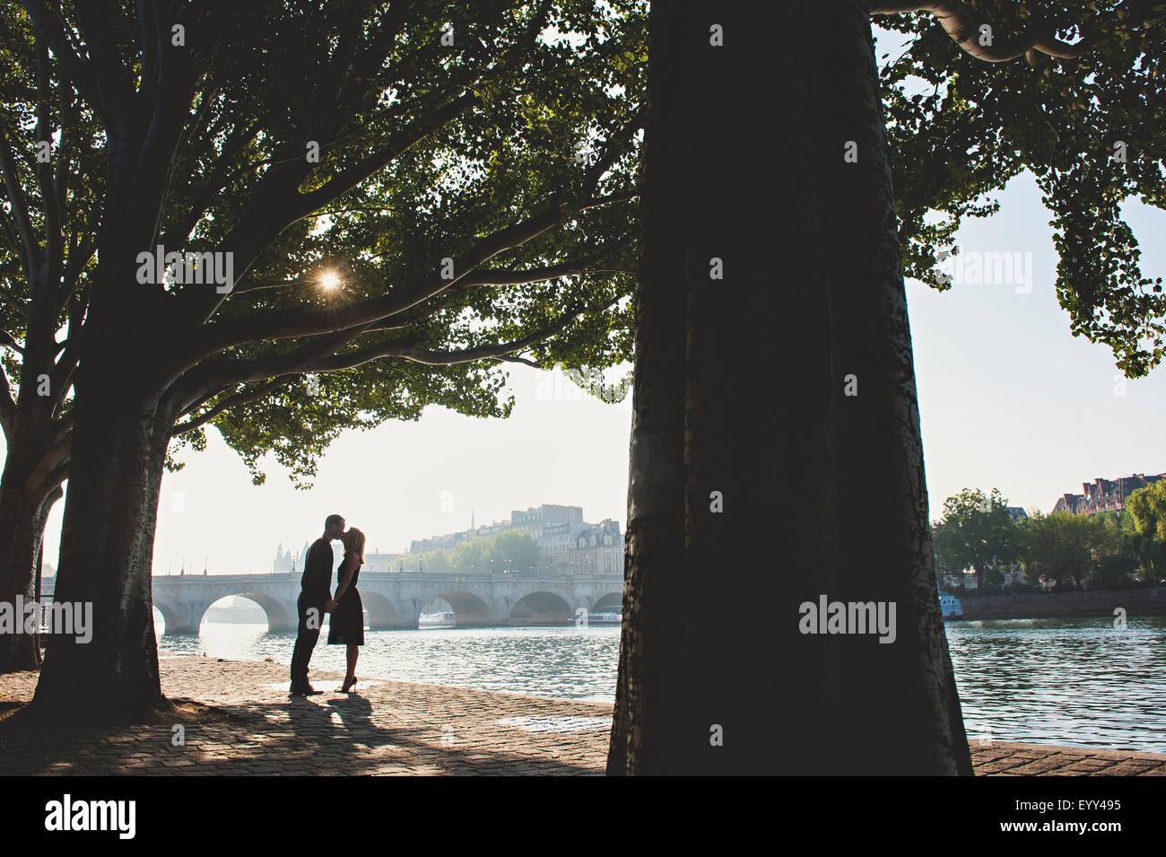 Caucasian couple kissing near bridge, Paris, Ile-de-France, France Stock Photo