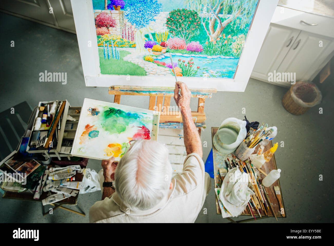 Caucasian artist painting in studio Stock Photo