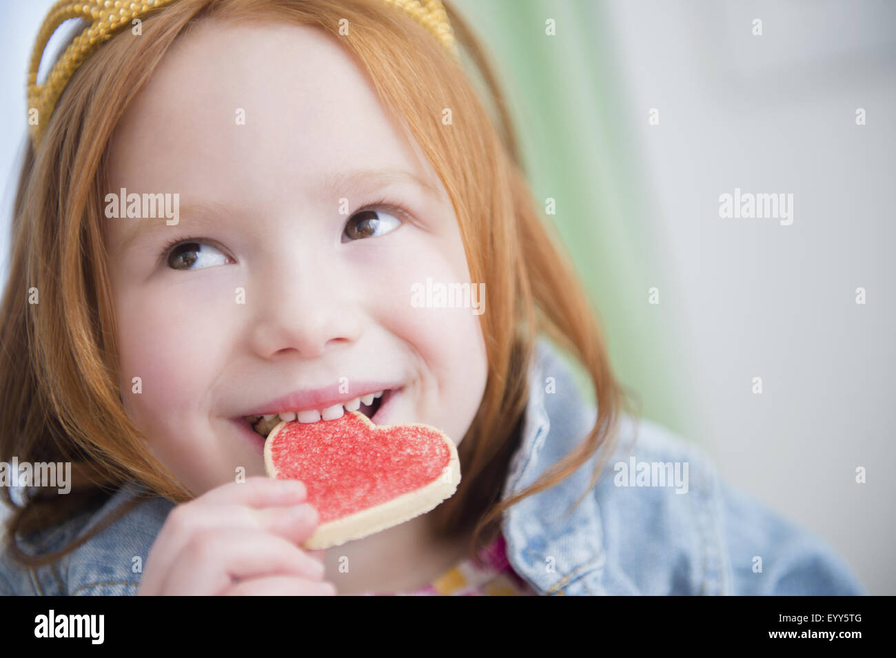 Caucasian girl eating heartshape cookie Stock Photo Alamy