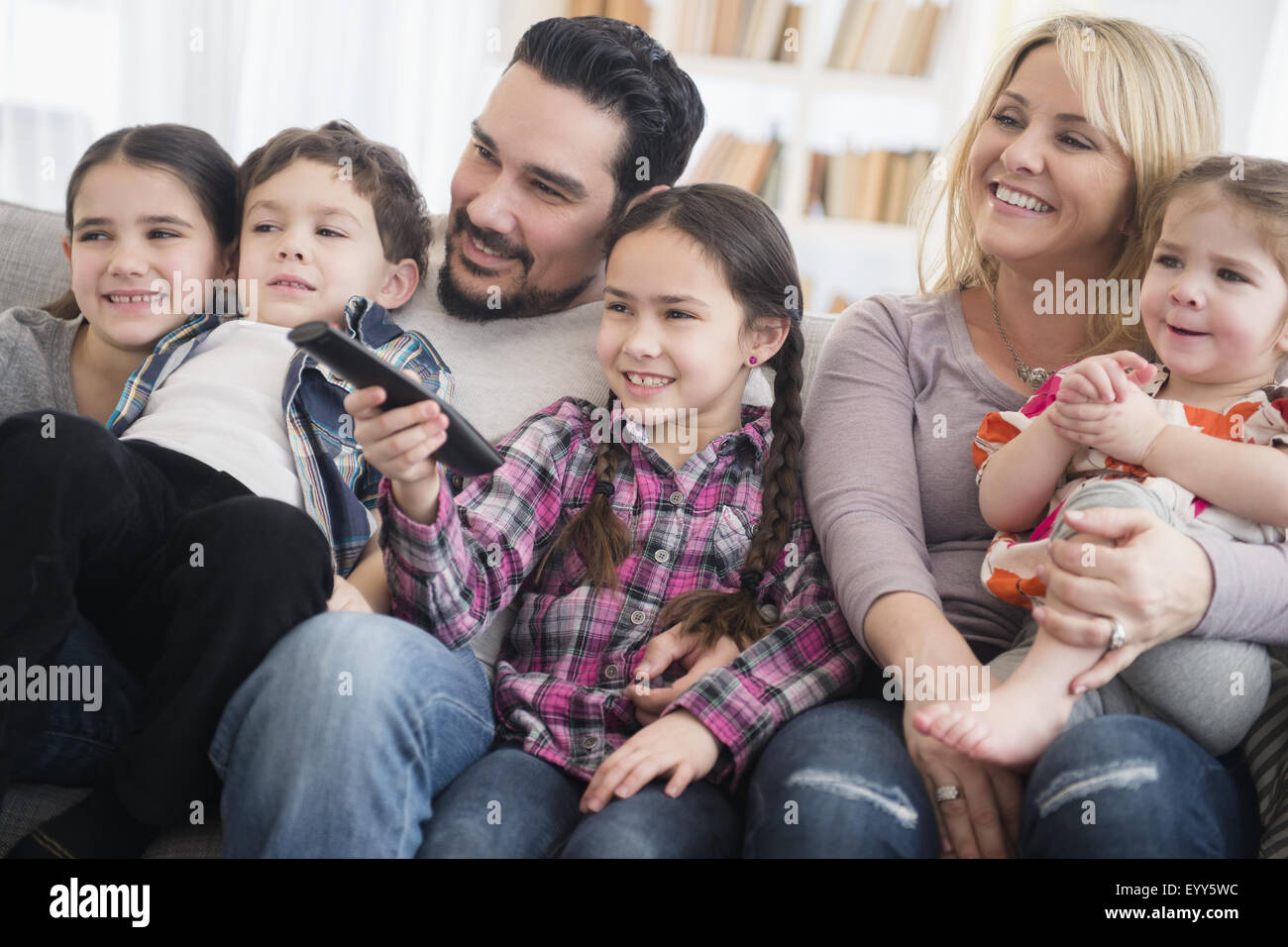 Caucasian parents and children smiling in living room Stock Photo