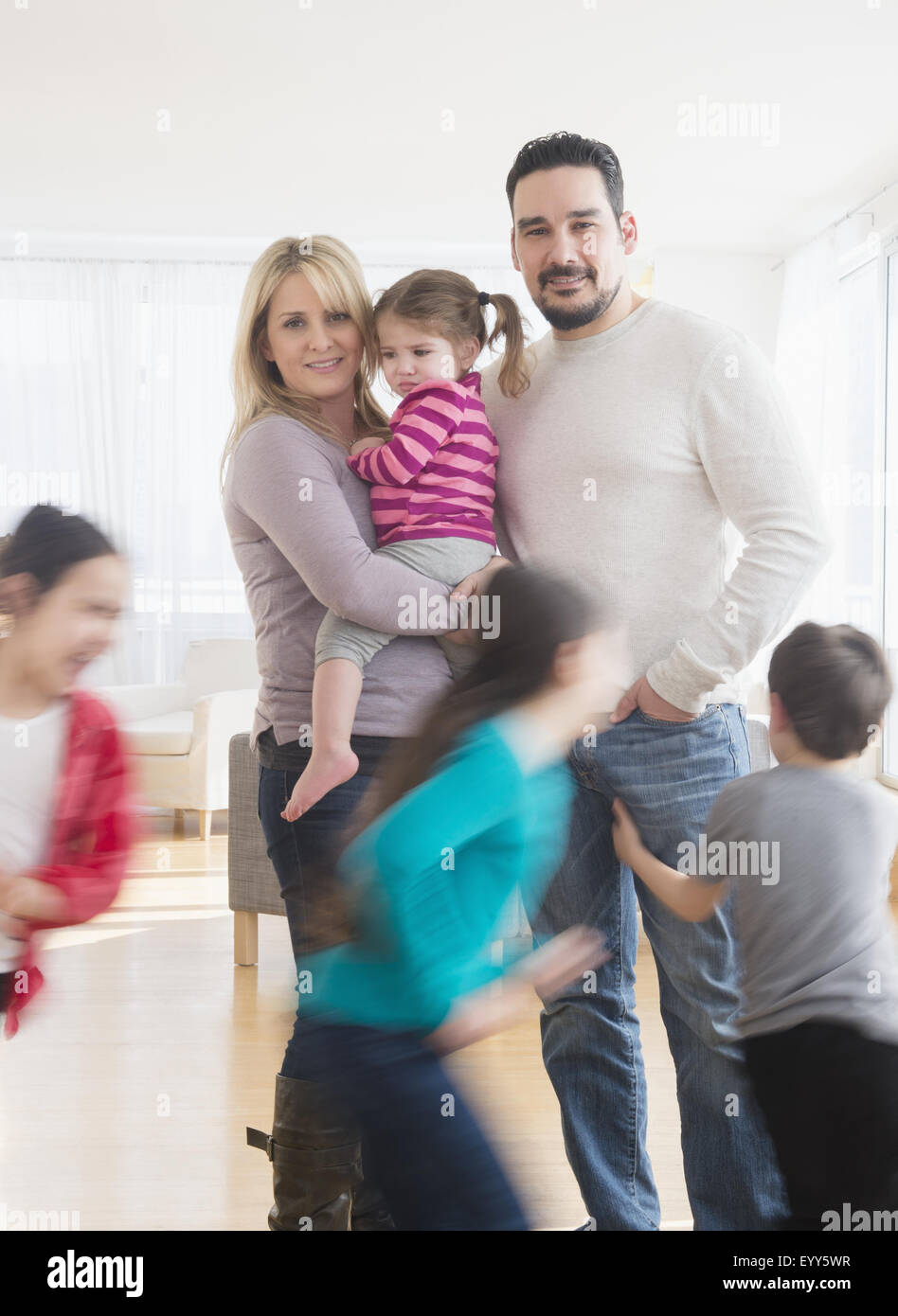 Caucasian parents busy with running children Stock Photo