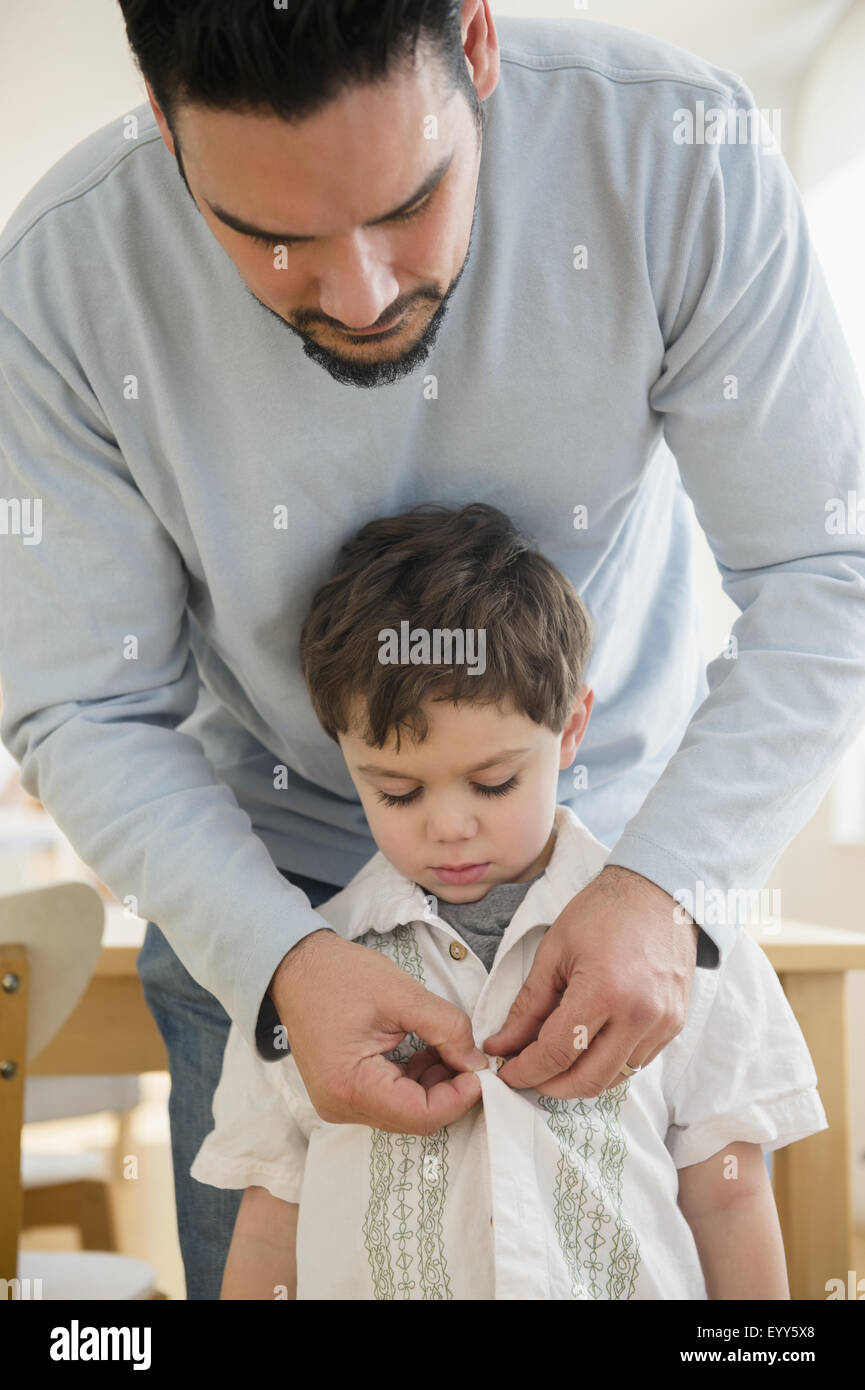 Caucasian Father Buttoning Shirt For Son Stock Photo Alamy