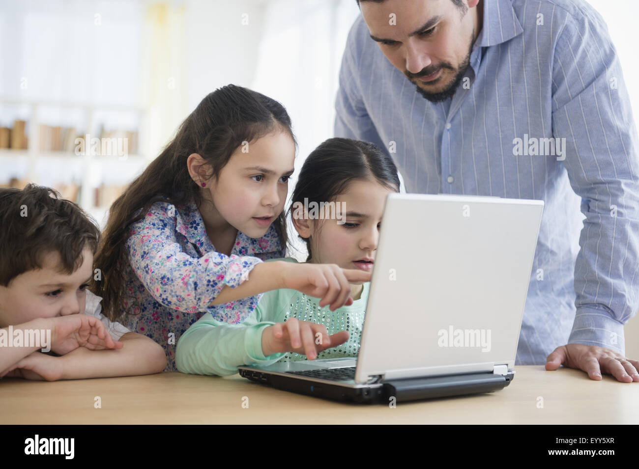 Caucasian father and children using laptop Stock Photo