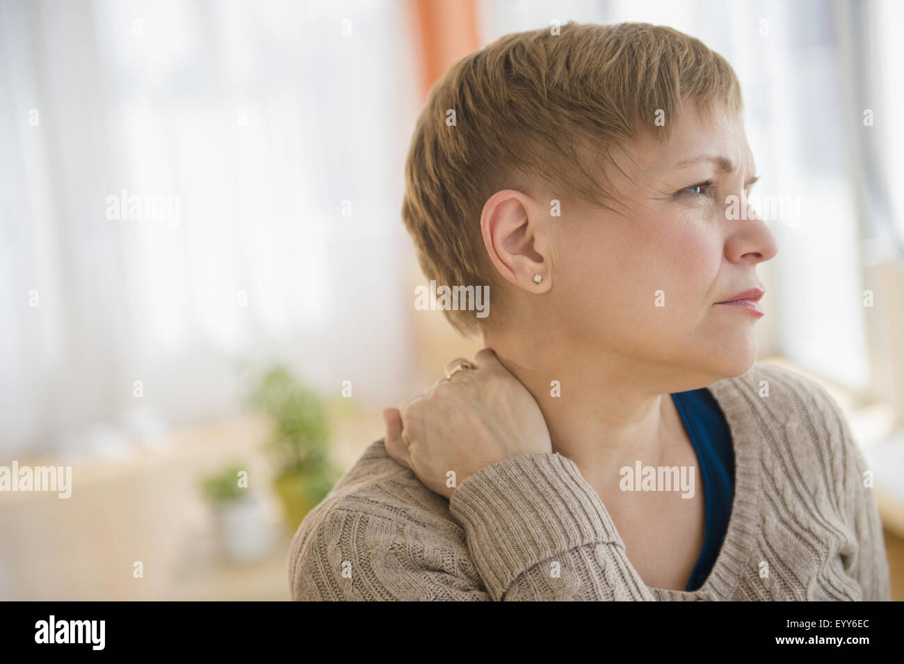 Anxious Caucasian woman rubbing her neck Stock Photo