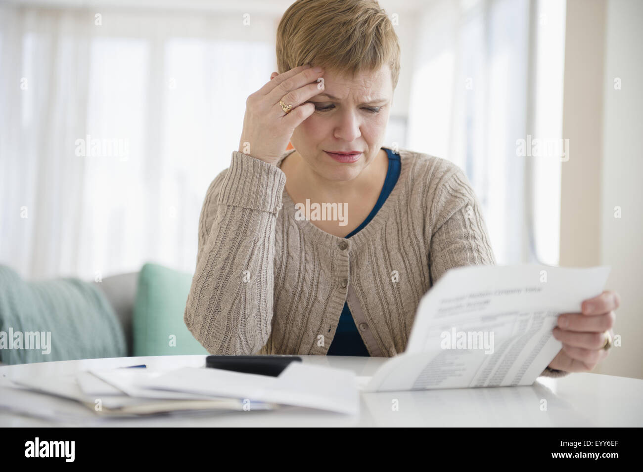 Anxious Caucasian woman paying bills Stock Photo