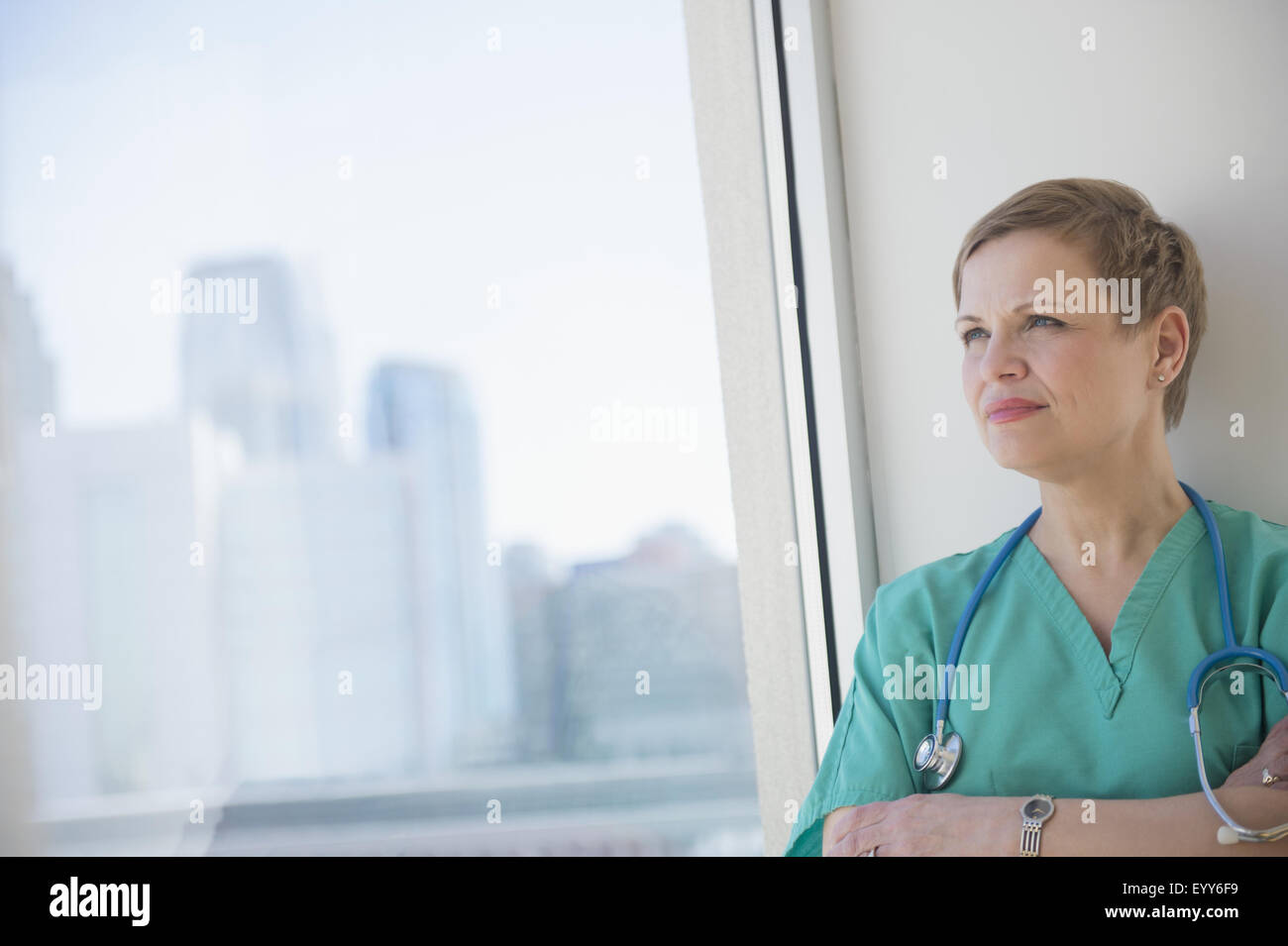 Caucasian nurse near window Stock Photo - Alamy