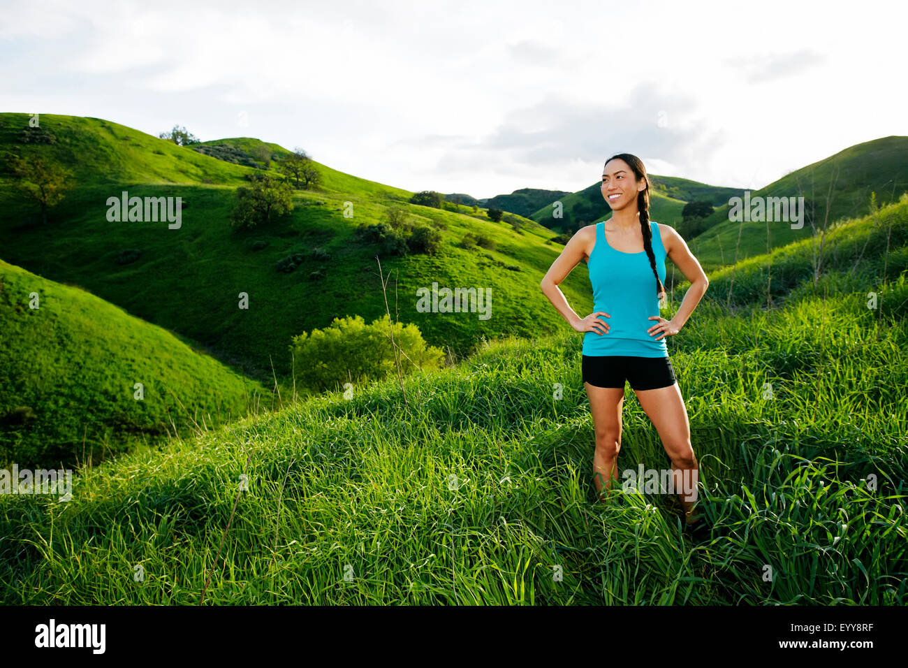 Mixed race athlete standing on rural hillside Stock Photo