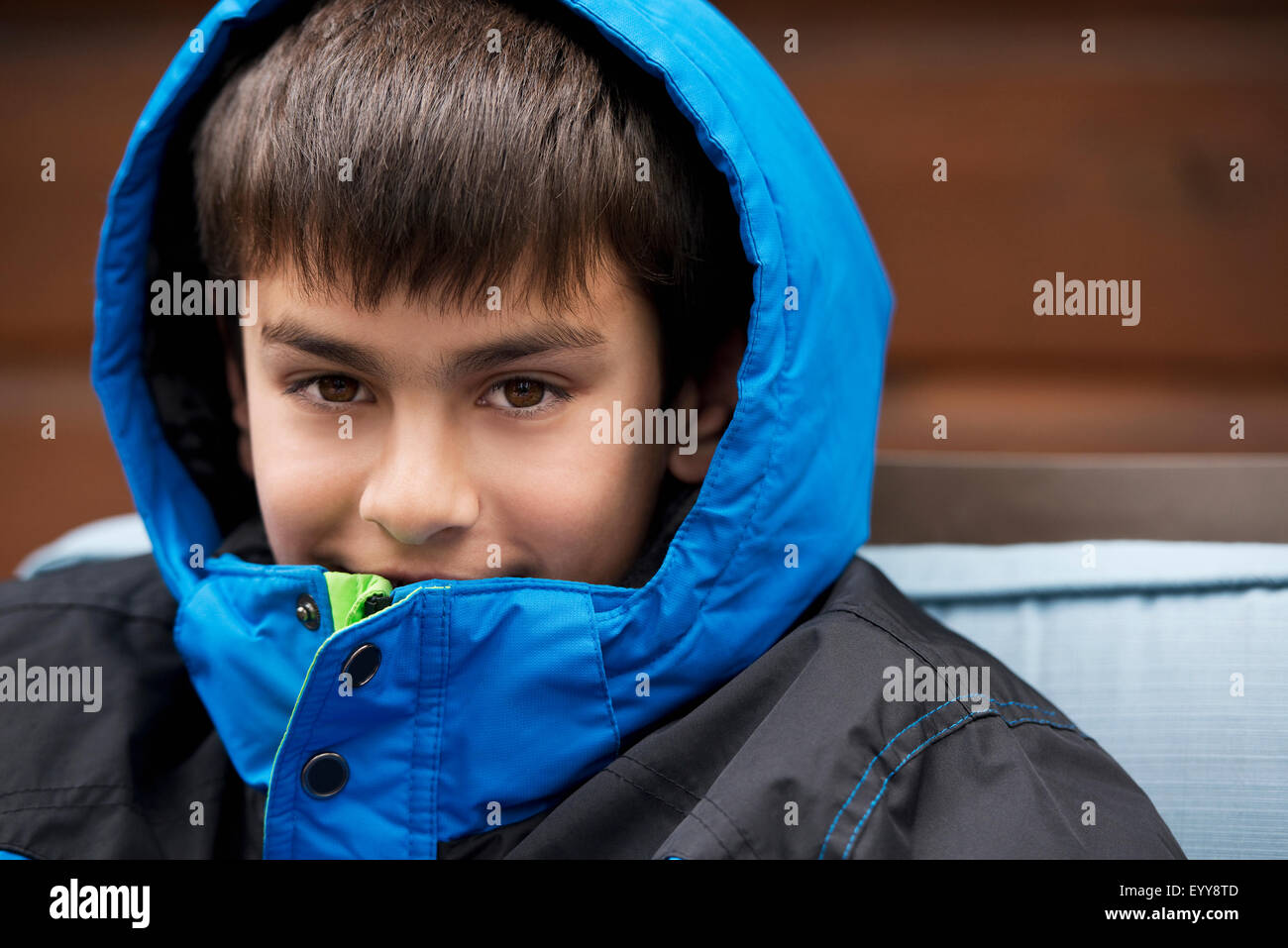 Close up of mixed race boy wearing parka and hood Stock Photo