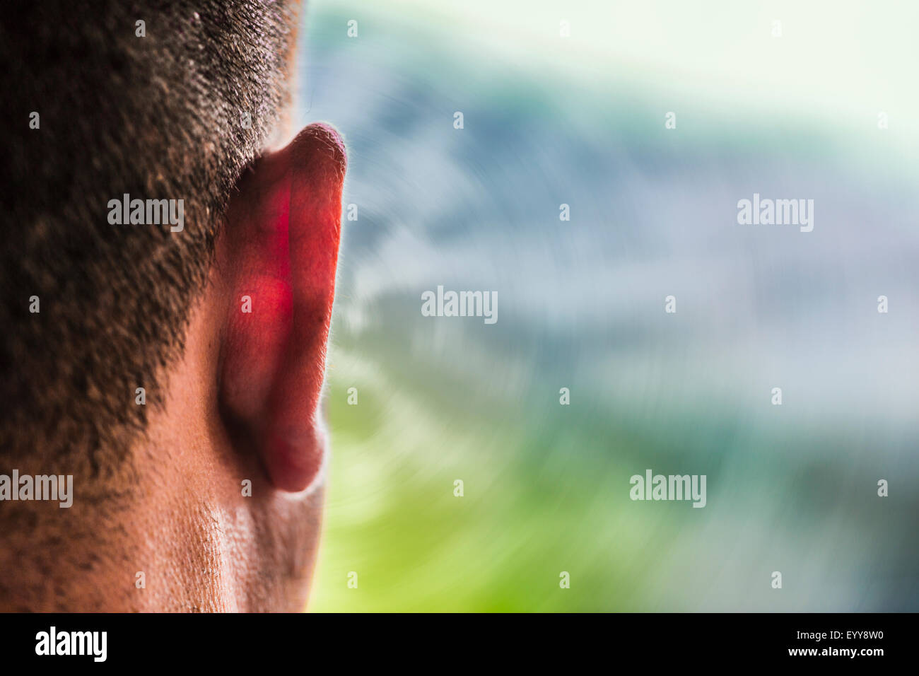Close up of ear of Caucasian man and sound waves Stock Photo