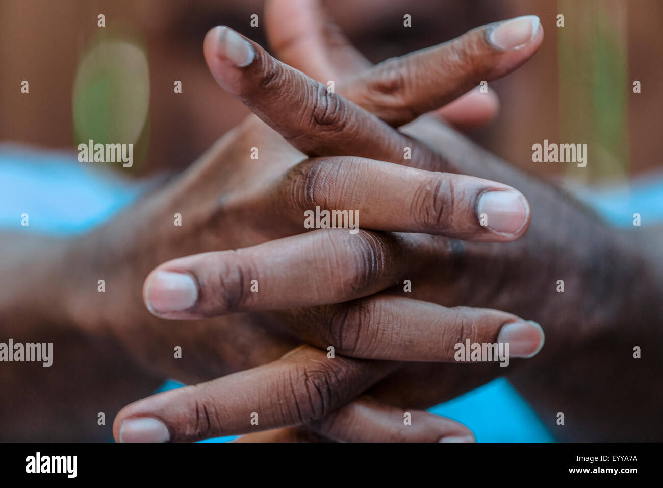 Close up of intertwined fingers of Black man Stock Photo