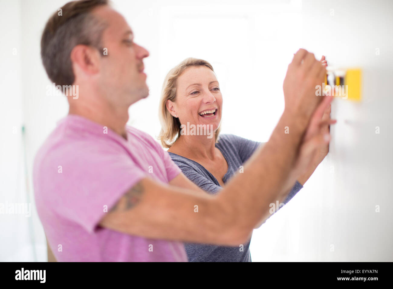 Caucasian couple using level in new home Stock Photo