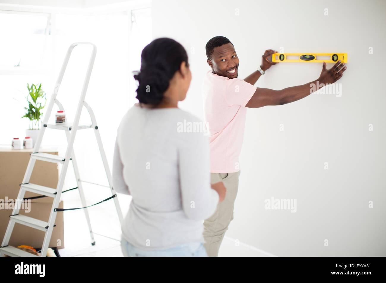 Couple using level in new home Stock Photo