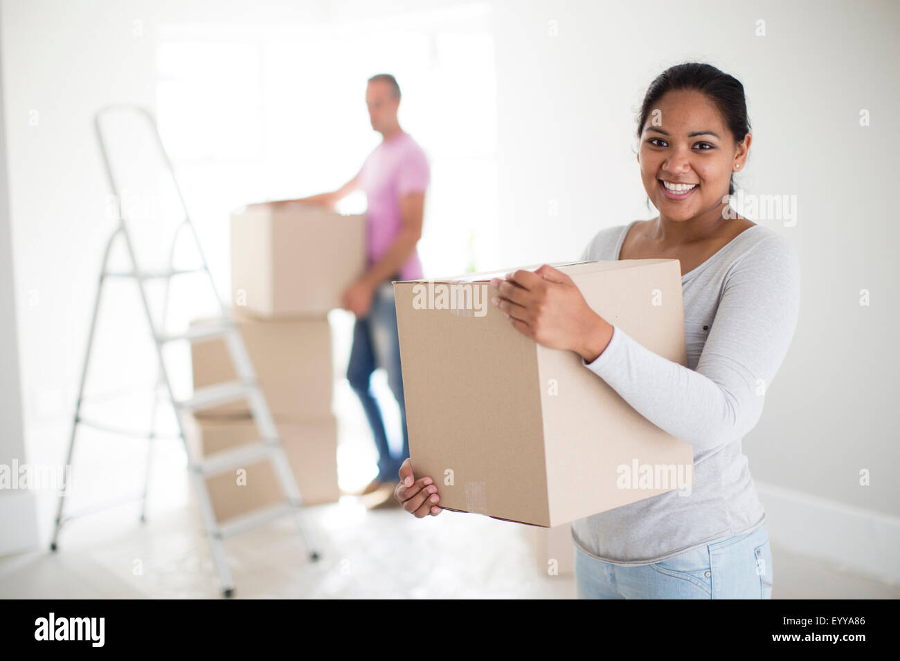 Couple holding cardboard boxes in new home Stock Photo