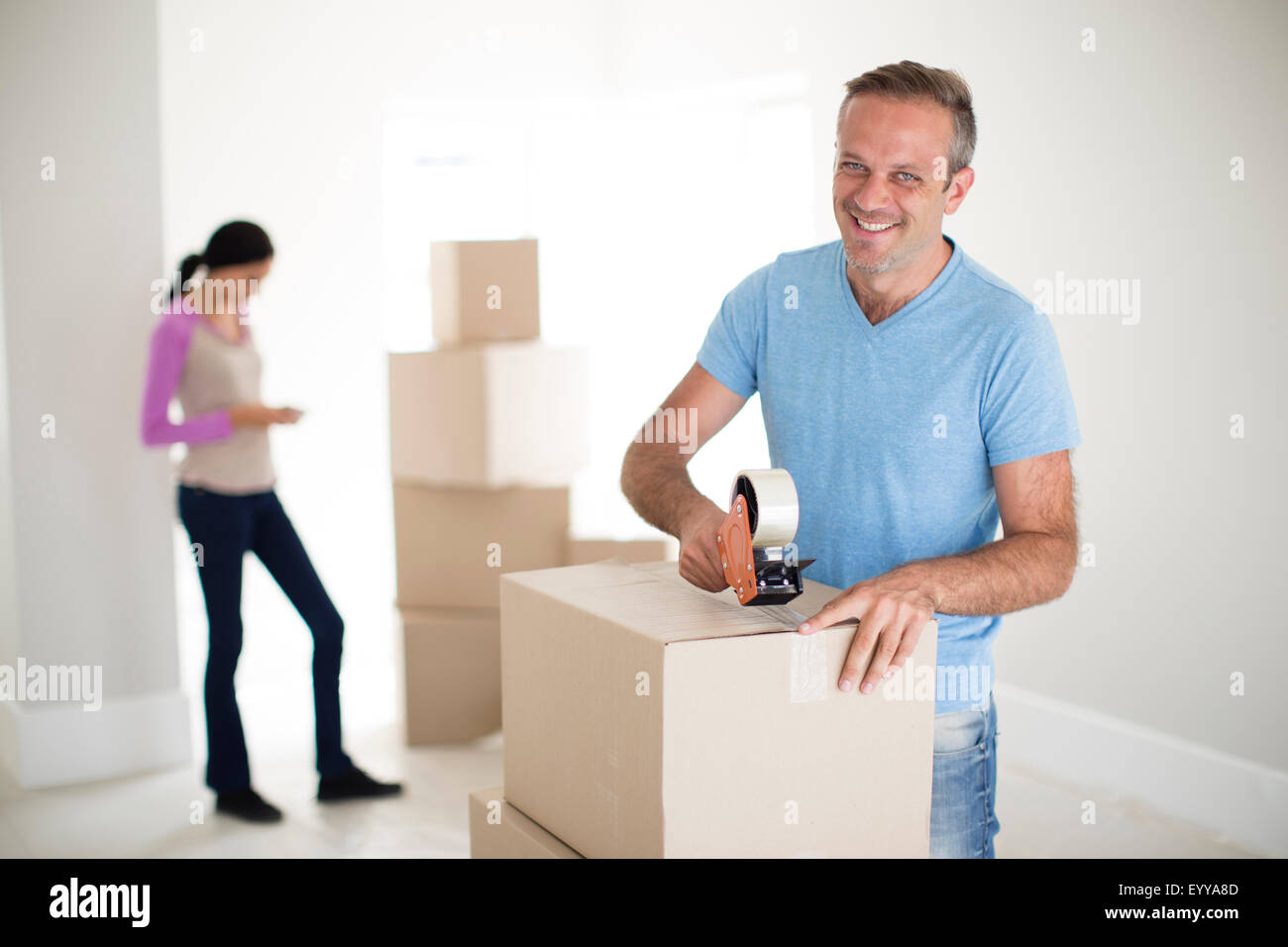 Man taping cardboard box to move Stock Photo