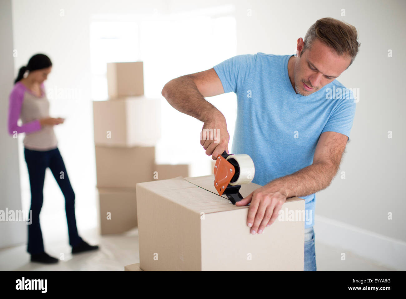 Man taping cardboard box to move Stock Photo