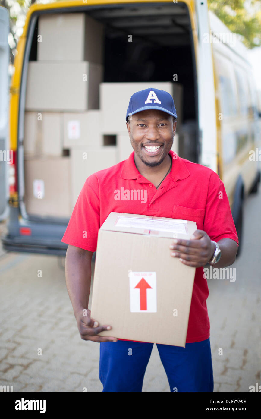 Black delivery man holding package Stock Photo