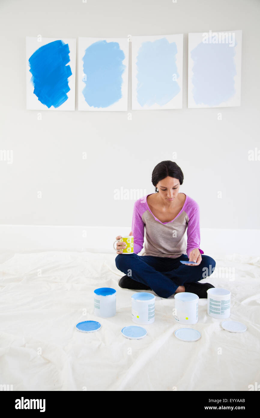 Mixed race woman examining paint samples in new home Stock Photo