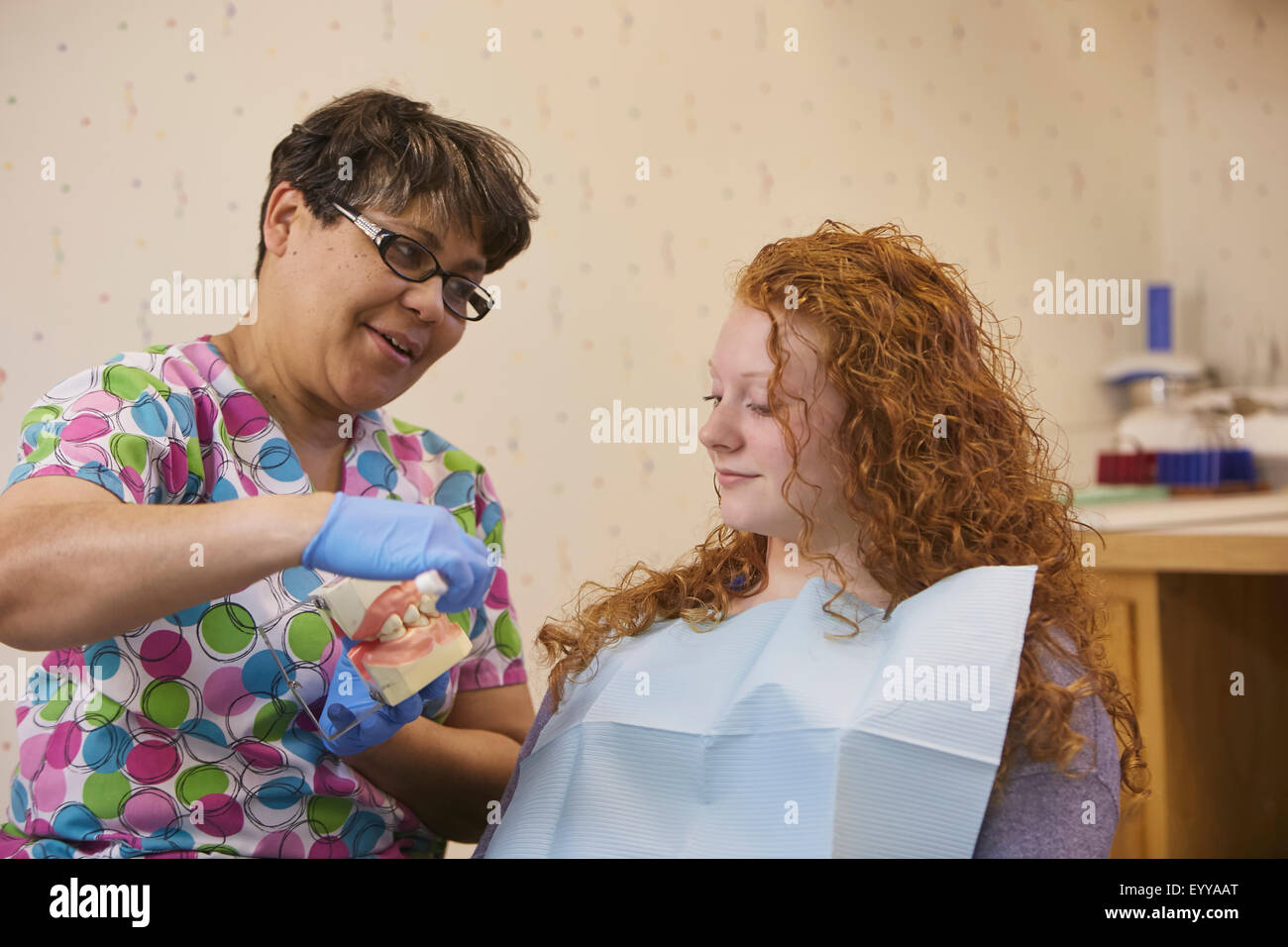 Pediatric dentist showing teeth model to teenage patient Stock Photo