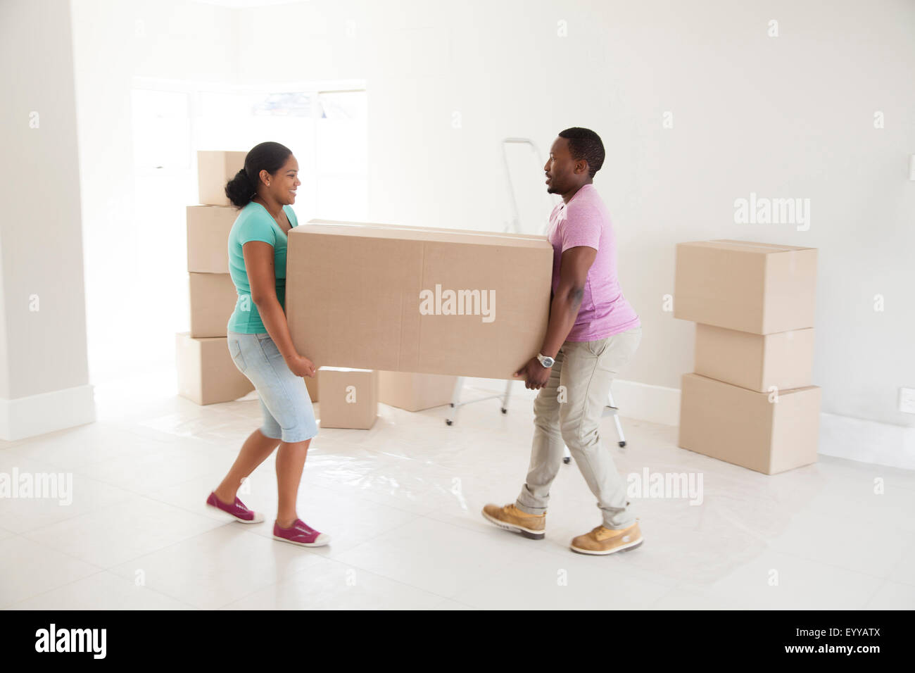Couple carrying cardboard box in new home Stock Photo