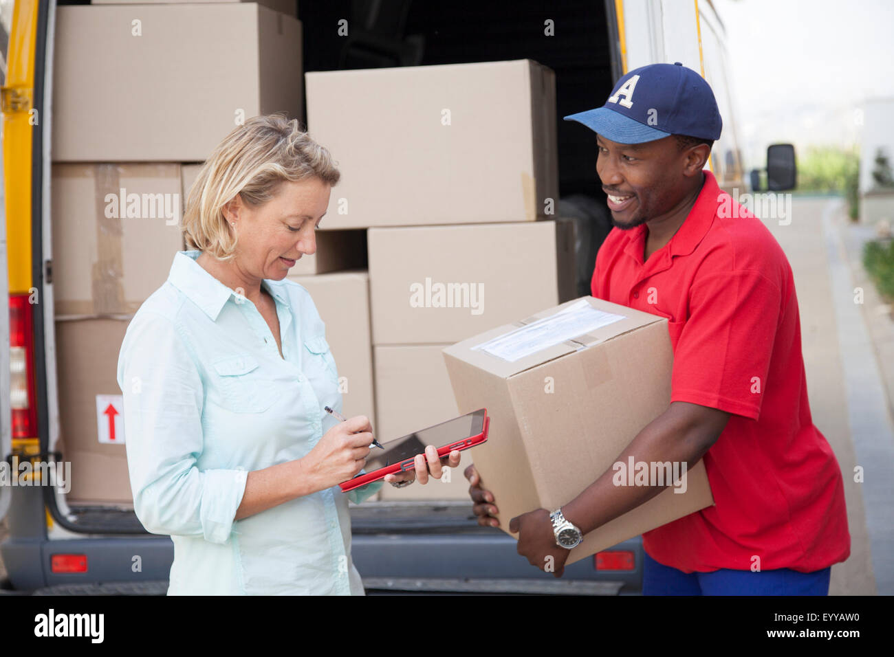 Delivery man holding cardboard box with customer Stock Photo