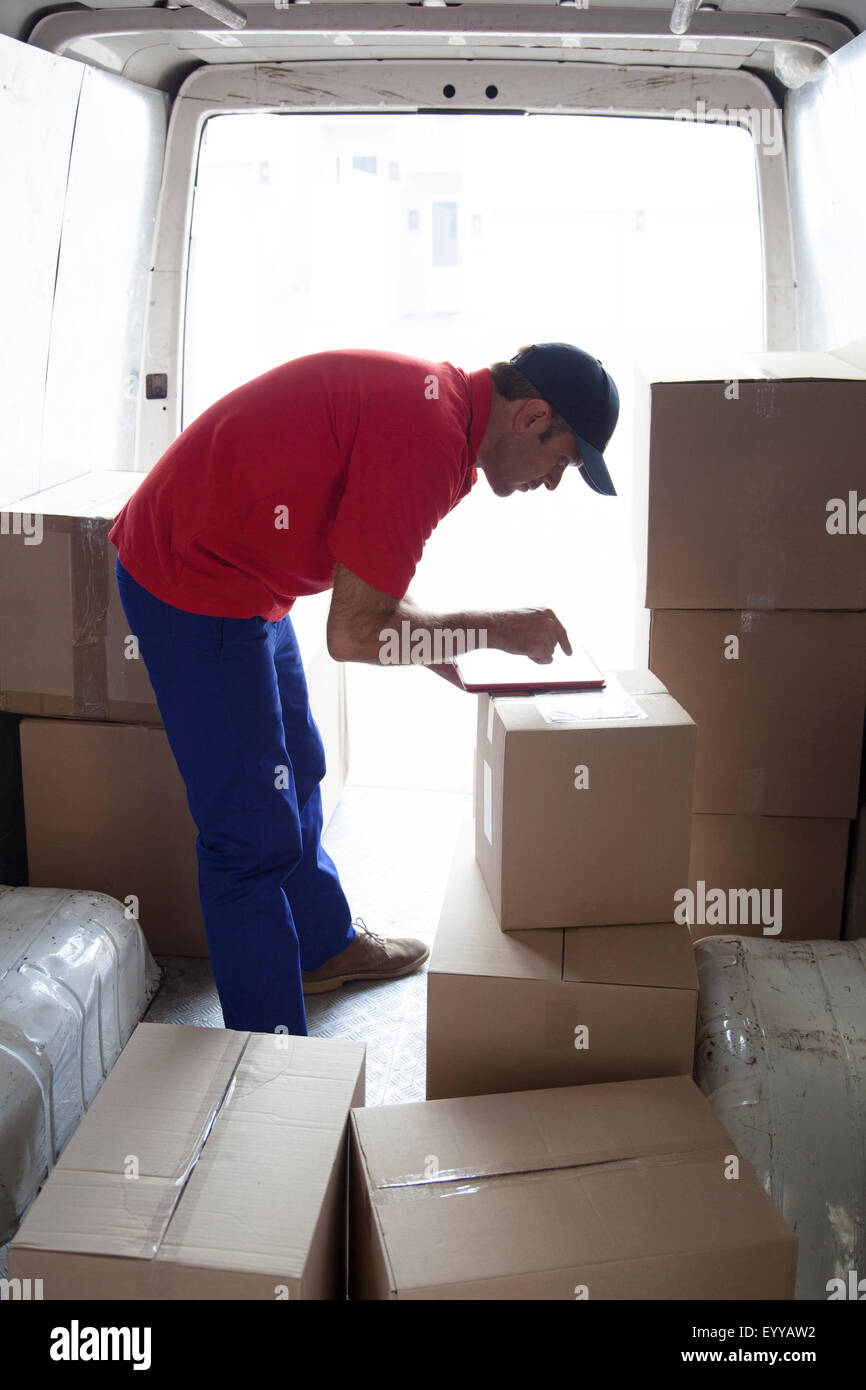 Caucasian delivery man using digital tablet in van Stock Photo