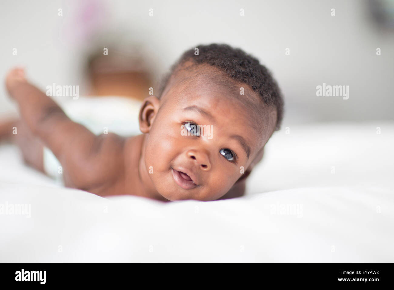 Close up of Black baby laying on bed Stock Photo