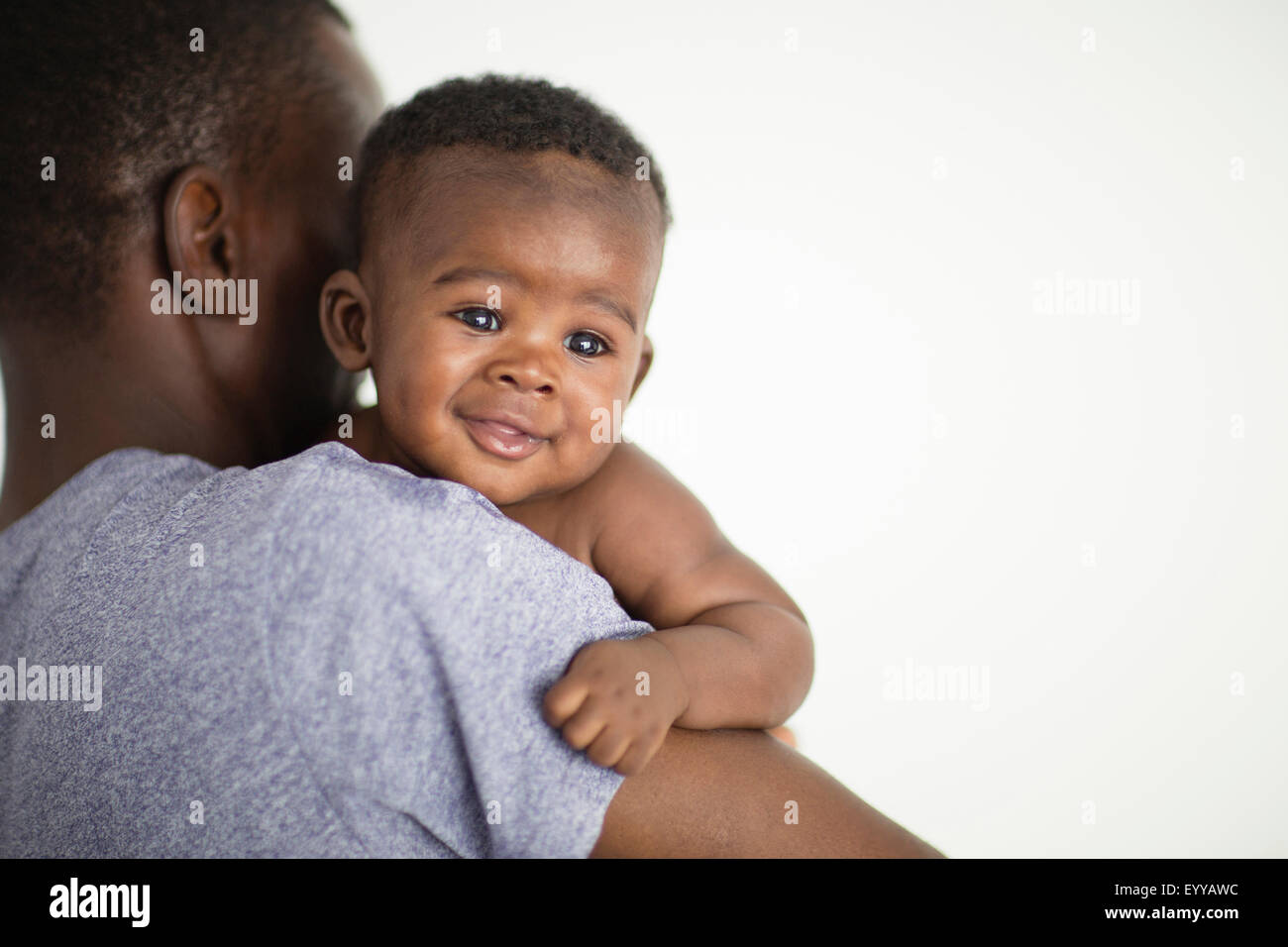 Close up of Black father carrying baby Stock Photo