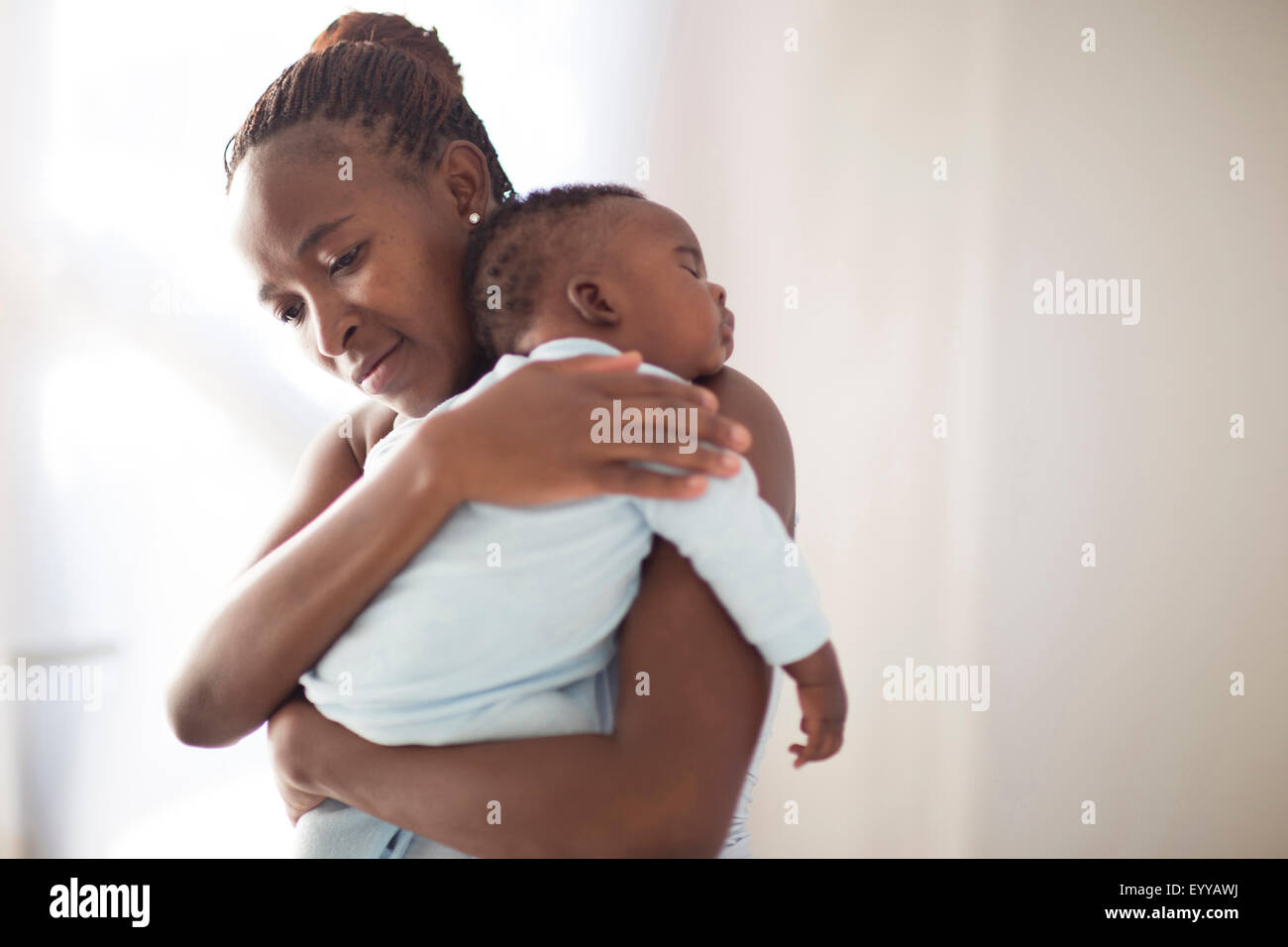 Black mother holding sleeping baby Stock Photo