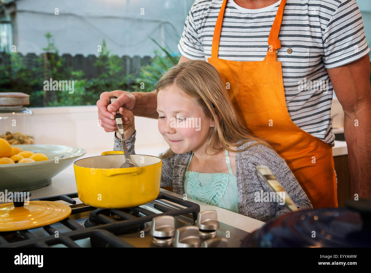 Caucasian father and daughter cooking in kitchen Stock Photo