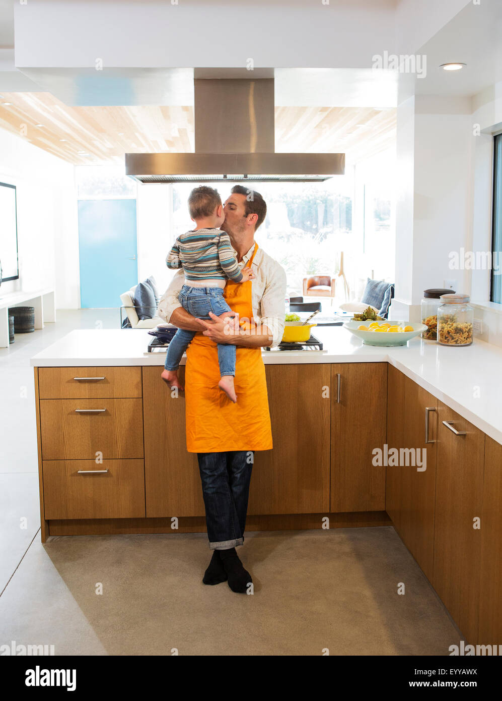 Caucasian father kissing daughter in kitchen Stock Photo