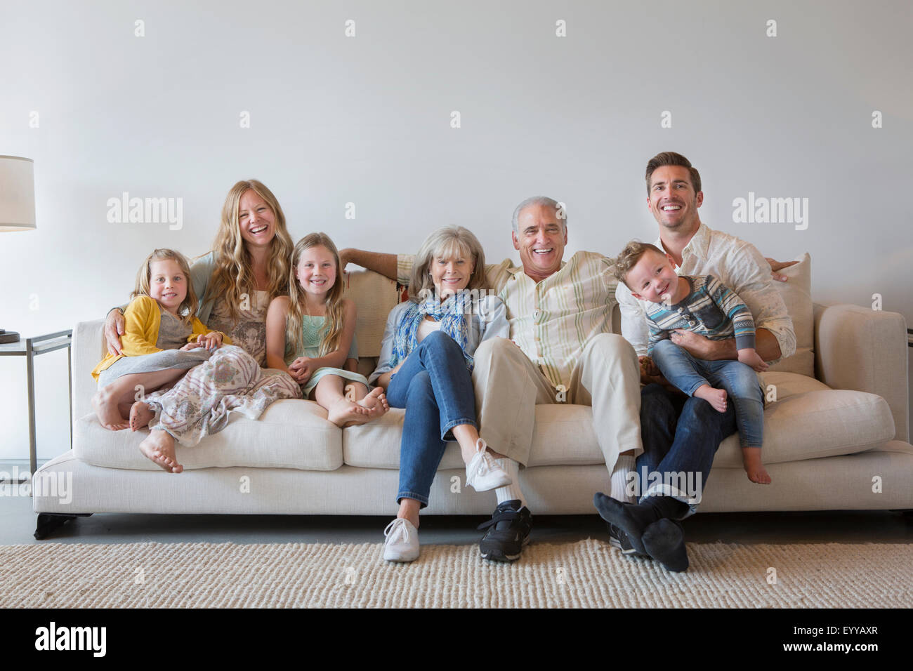Caucasian multi-generation family sitting on sofa in living room Stock Photo