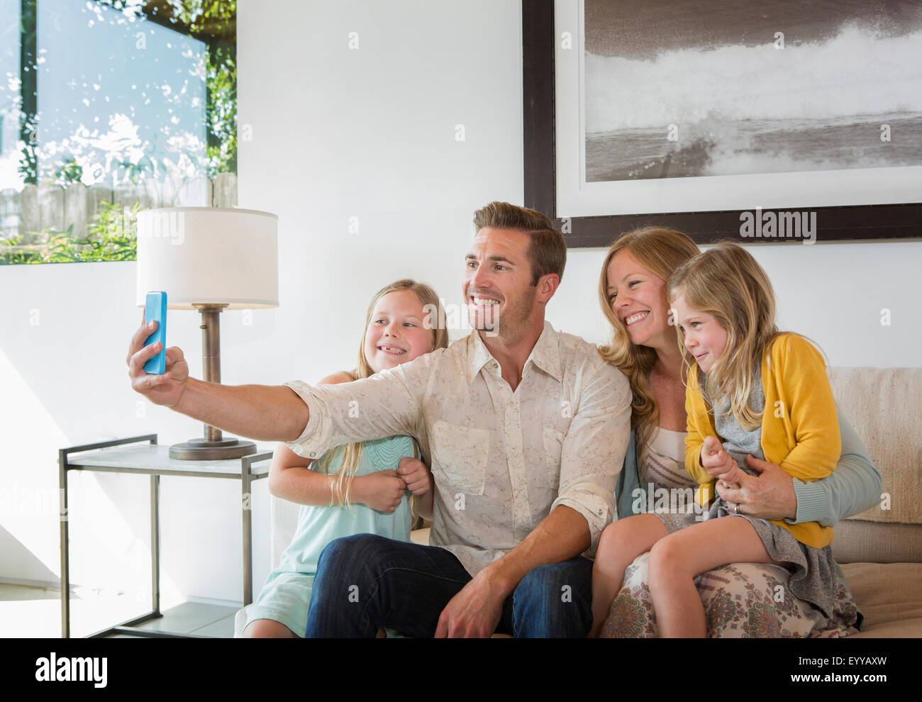 Caucasian family taking selfie on sofa Stock Photo