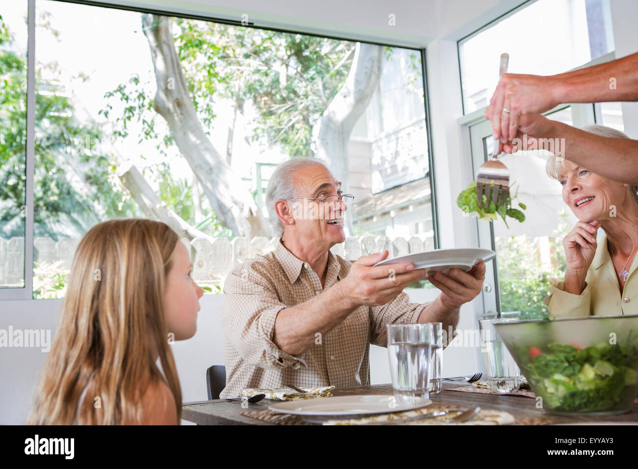 Caucasian multi-generation family eating at table Stock Photo