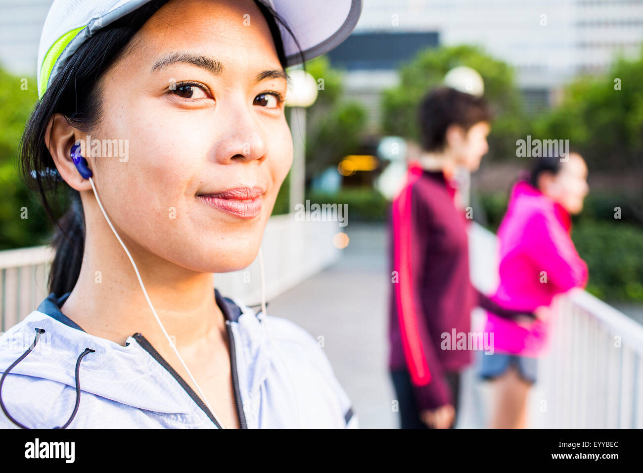 Runner listening to earbud in city Stock Photo