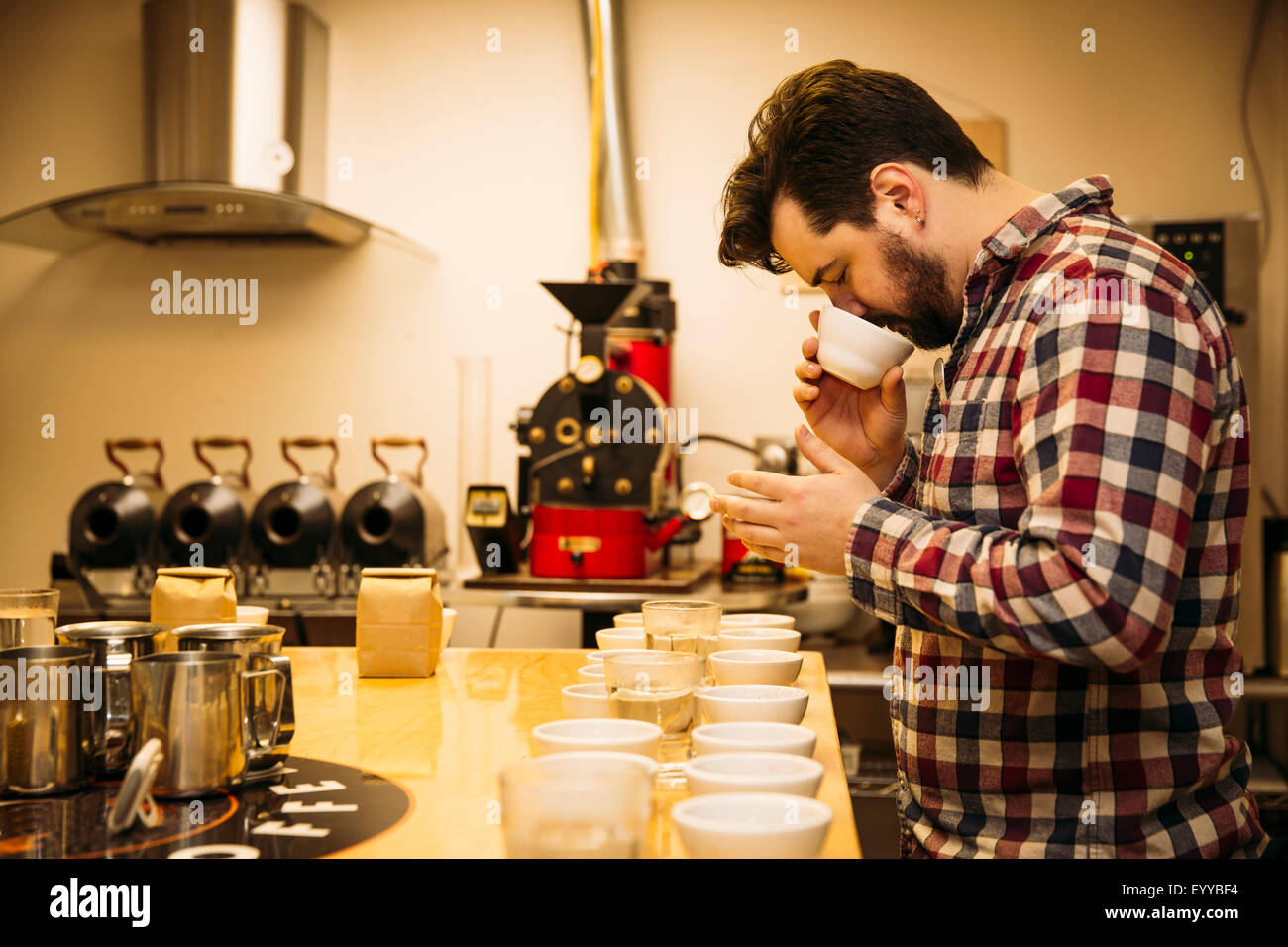 Caucasian barista tasting coffee in coffee shop Stock Photo