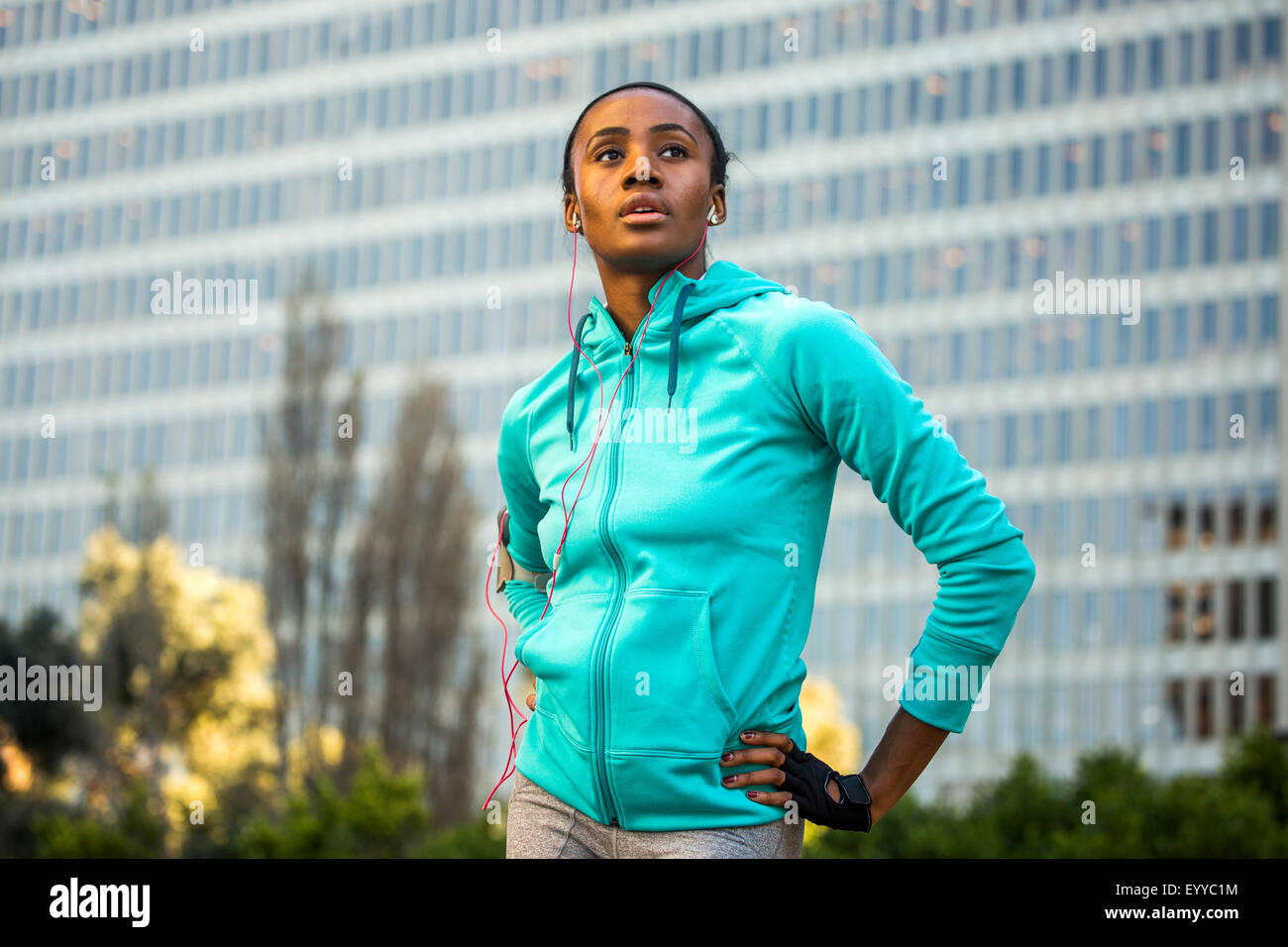 Black runner standing near high rise building Stock Photo