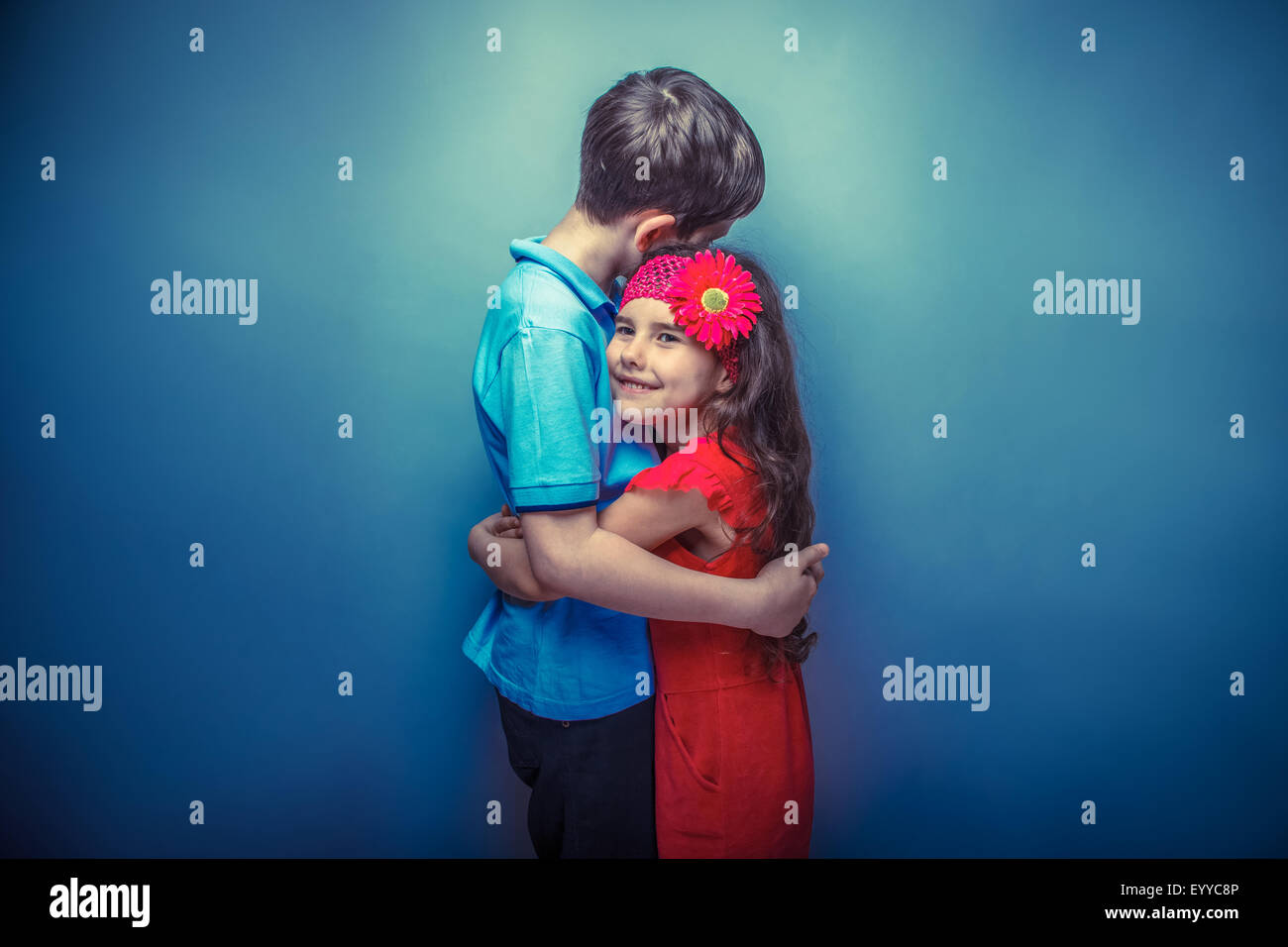 teen  girl hugging a  teenage  boy on a gray  background retro p Stock Photo