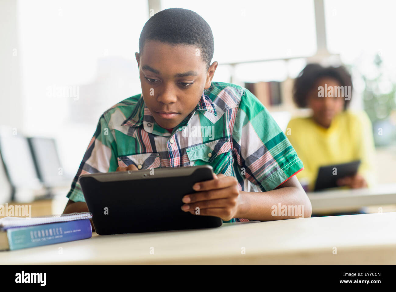 Black student using digital tablet in classroom Stock Photo